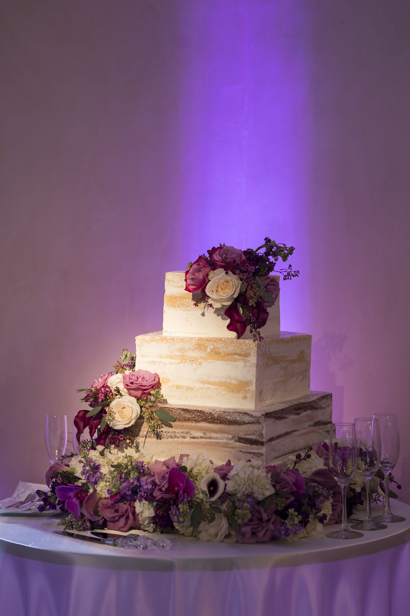 square nearly naked wedding cake covered in roses at noor los angeles banquet hall