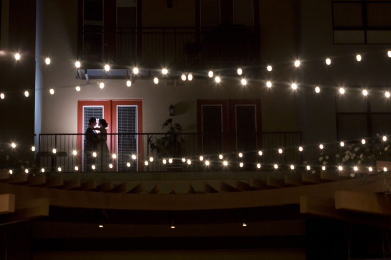 bride and groom kissing in silhouette on the balcony of the NOOR wedding suite