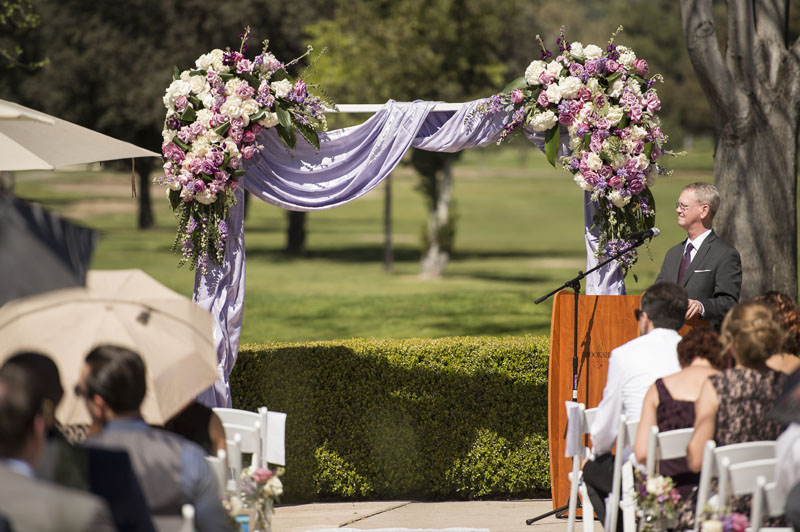 wedding arch draped with lilac fabric and roses