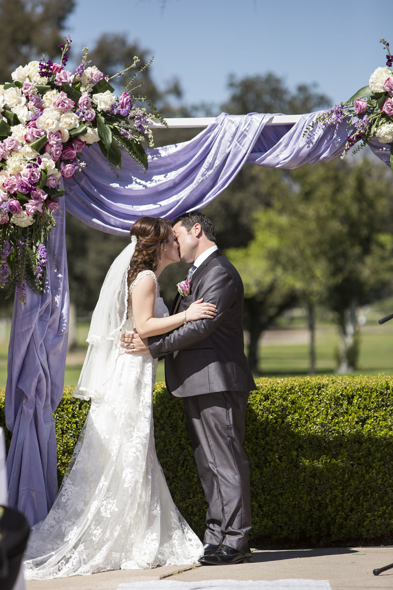 bride and groom first kiss underneath a beautiful wedding arch los angeles wedding