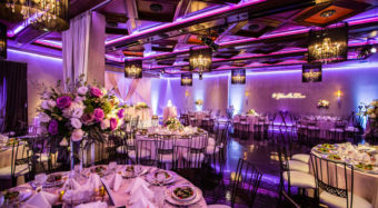 wedding reception view of the ella banquet hall with floral arrangements and chandeliers