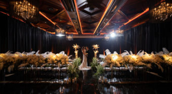 mardi gras themed wedding ceremony with floral arrangements and bride and groom