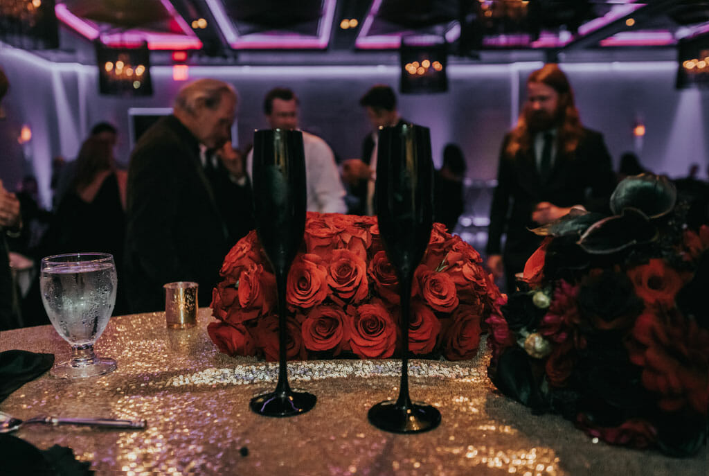 black champagne glasses with red wedding flowers alternative sweetheart table