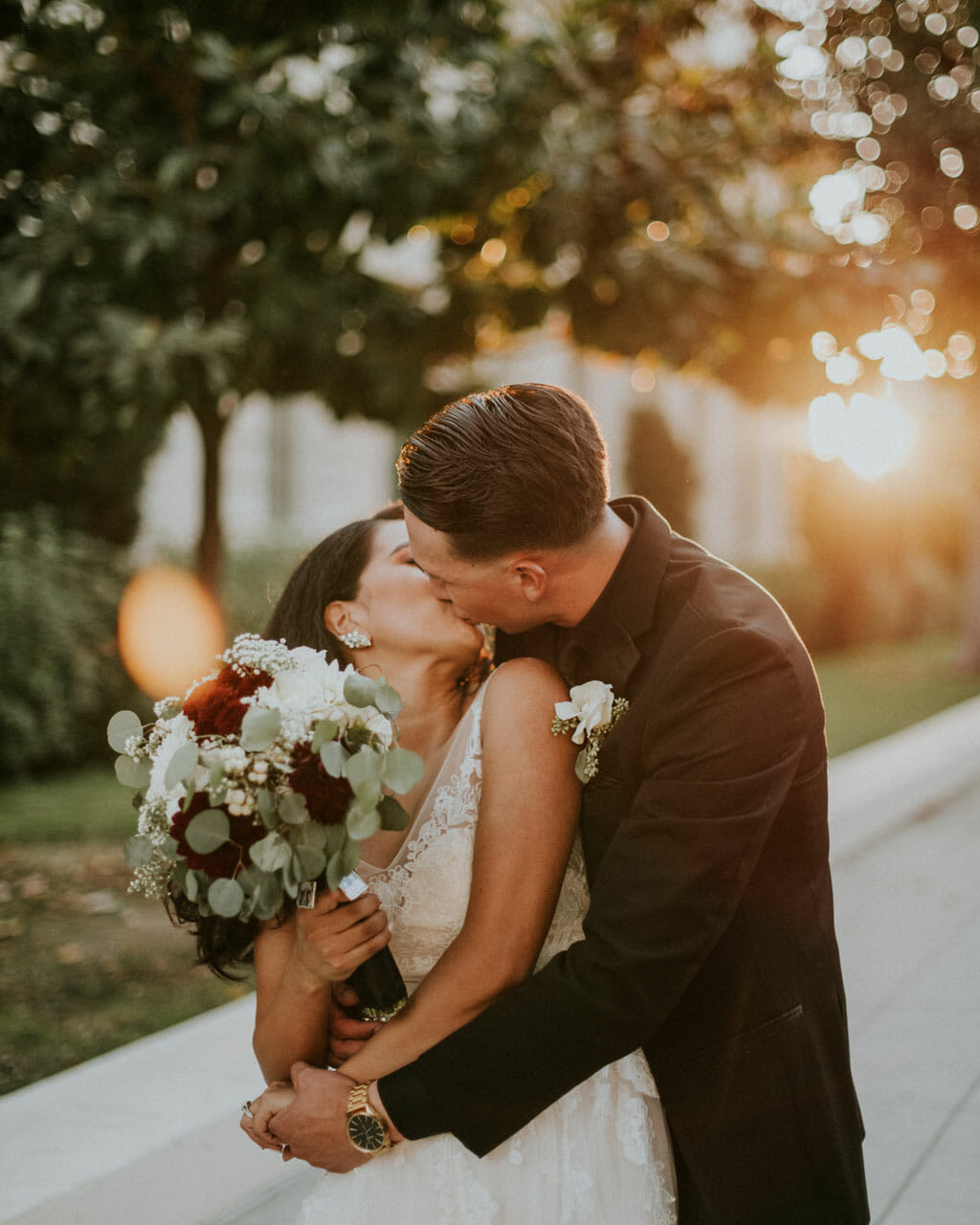wedding couple with bouquet kissing in golden hour light near noor banquet halls pasadena