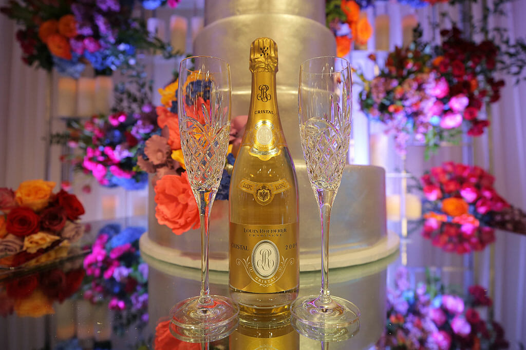 bottle of champagne next to weddinh cake and flowers at a wedding in pasadena