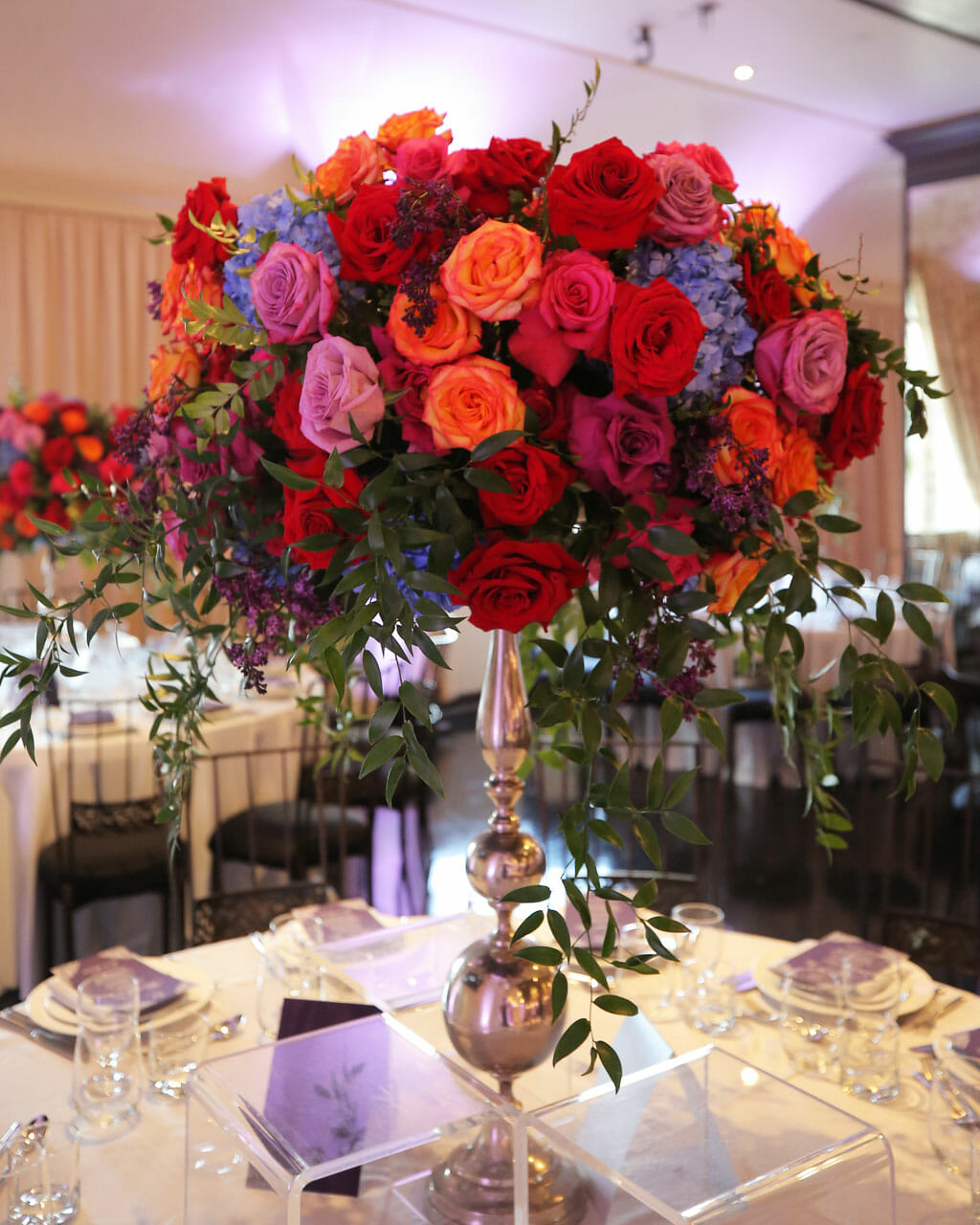 close up of red orange pink and blue floral centerpiece at NOOR sofa banquet hall in pasadena