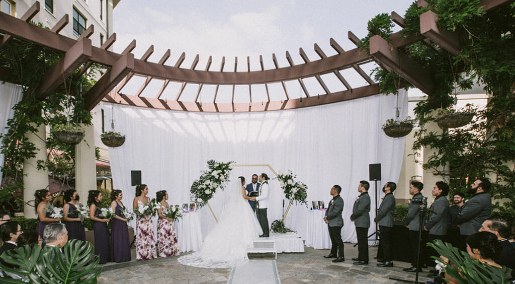 NOOR terrace wedding ceremony for outdoor weddings with bride and groom in front of floral arch
