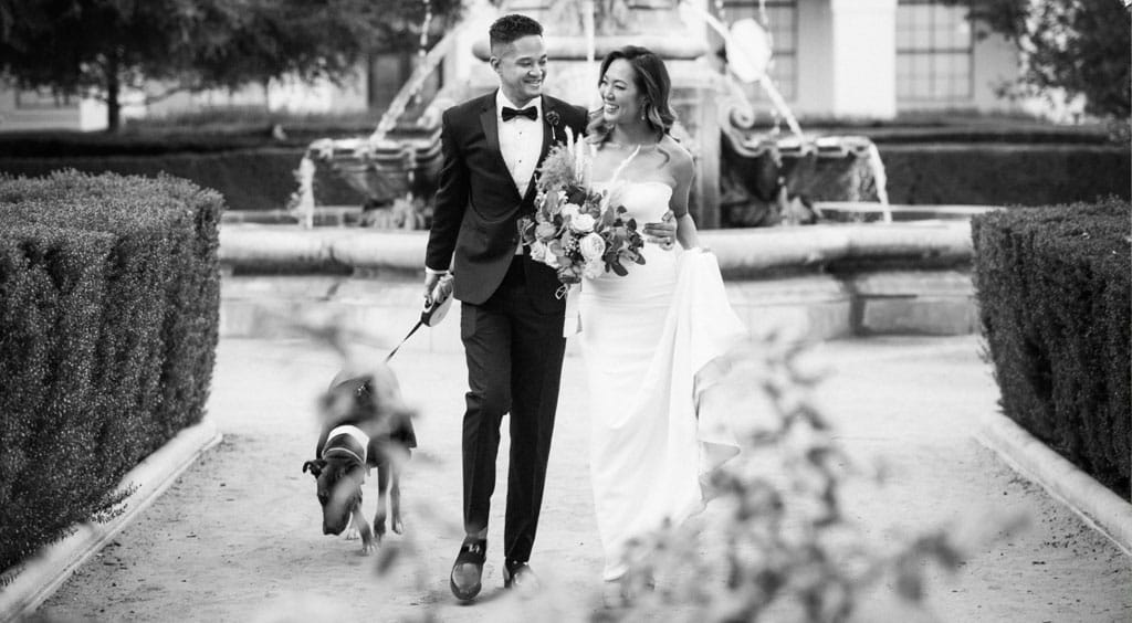 noor wedding couple with their dog walking and smiling outside the venue