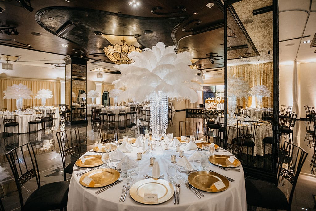 gatsby themed wedding at noor with feather centerpieces and gold and white table decor