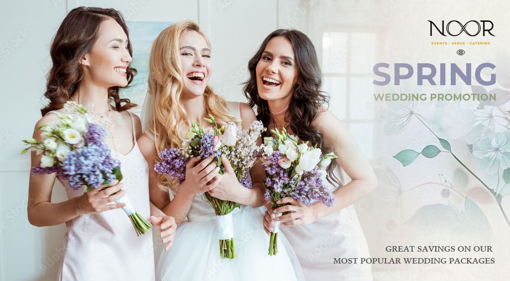 a bride with her bridesmaids laighing and smiling and holding bouquets of blue, purple and white flowers with green accents