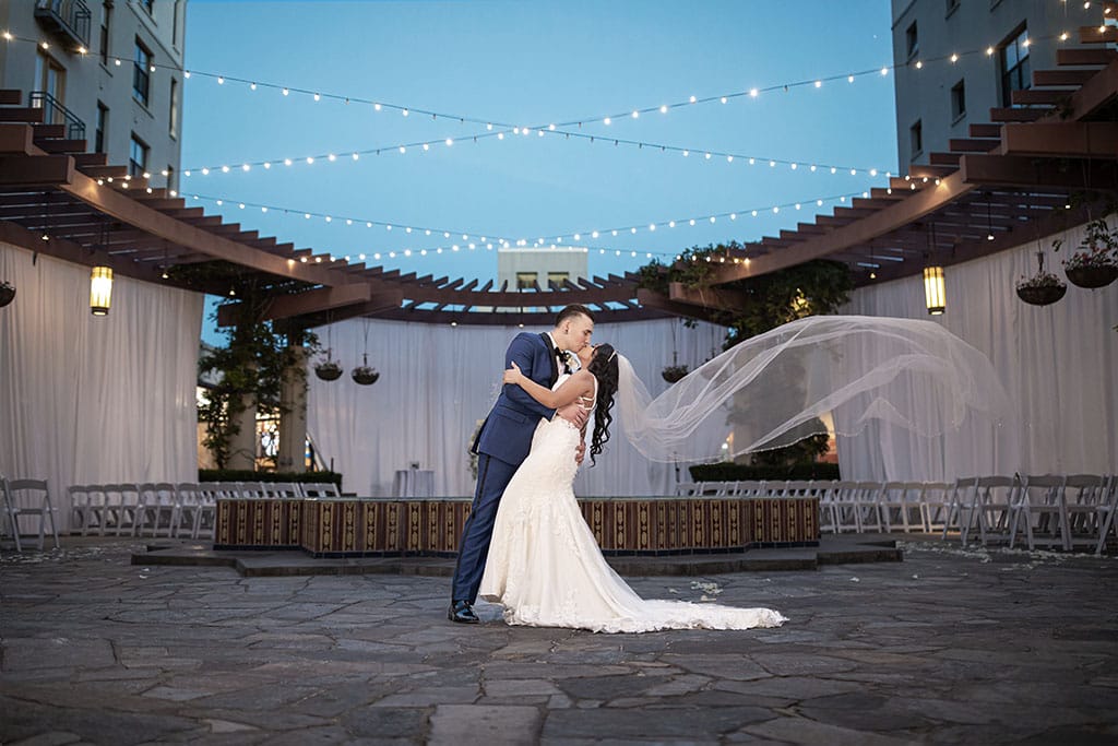 bride and groom dip kiss under a twilight sky on the noor terrace in pasadena