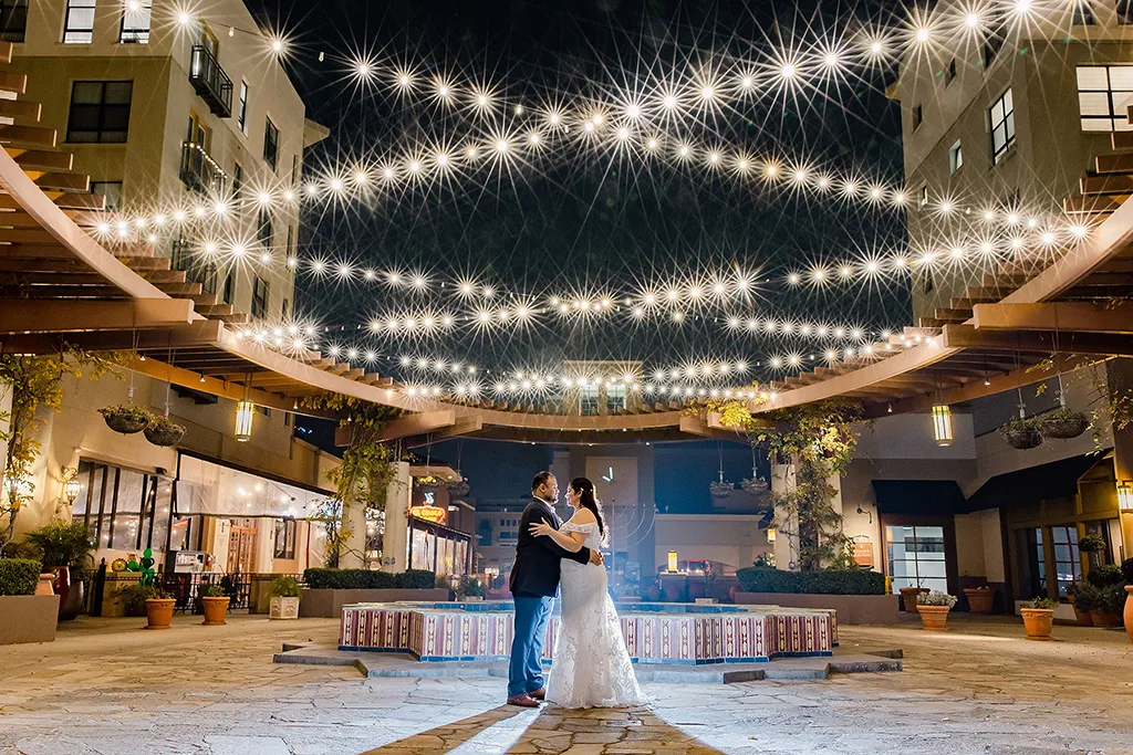 wedding couple embrace on The NOOR Terrace under strong lights