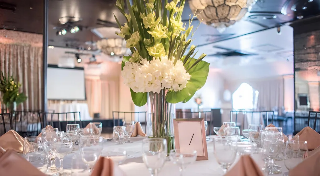 table setup with beautiful cream and greenery centerpiece at NOOR Pasadena